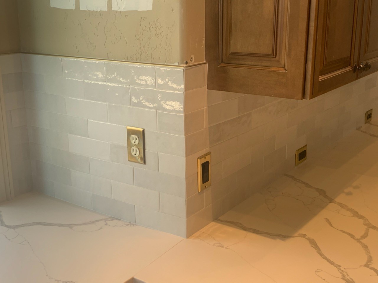 Up close of white subway tile and white countertop with grey veins
